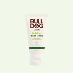 A 30 ml white tube of Travel Original Face Wash stands upright on a light green background, featuring brown and green text. This mens face wash is travel-sized and includes natural ingredients like Aloe Vera.