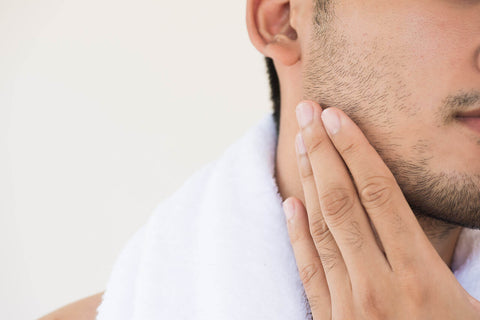 Young man touching his face