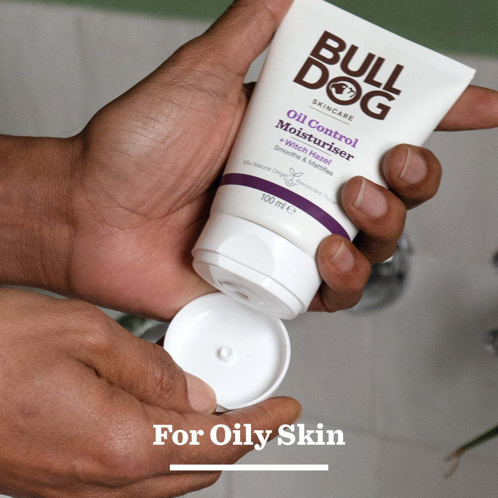 A person holds and squeezes a tube of Oil Control Moisturiser featuring natural origin ingredients. For Oily Skin is shown at the bottom, highlighting it as a top moisturiser for men with oily, acne-prone skin.
