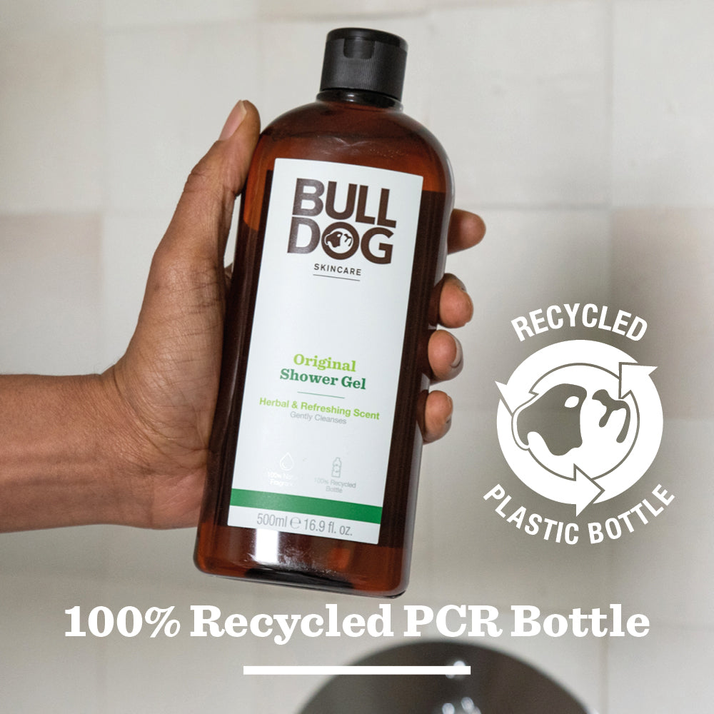 A hand holds a bottle of Original Shower Gel, known for natural ingredients. Beside it, a symbol with a dog and text reads: RECYCLED PLASTIC BOTTLE. Below that, the label states: 100% Recycled PCR Bottle.