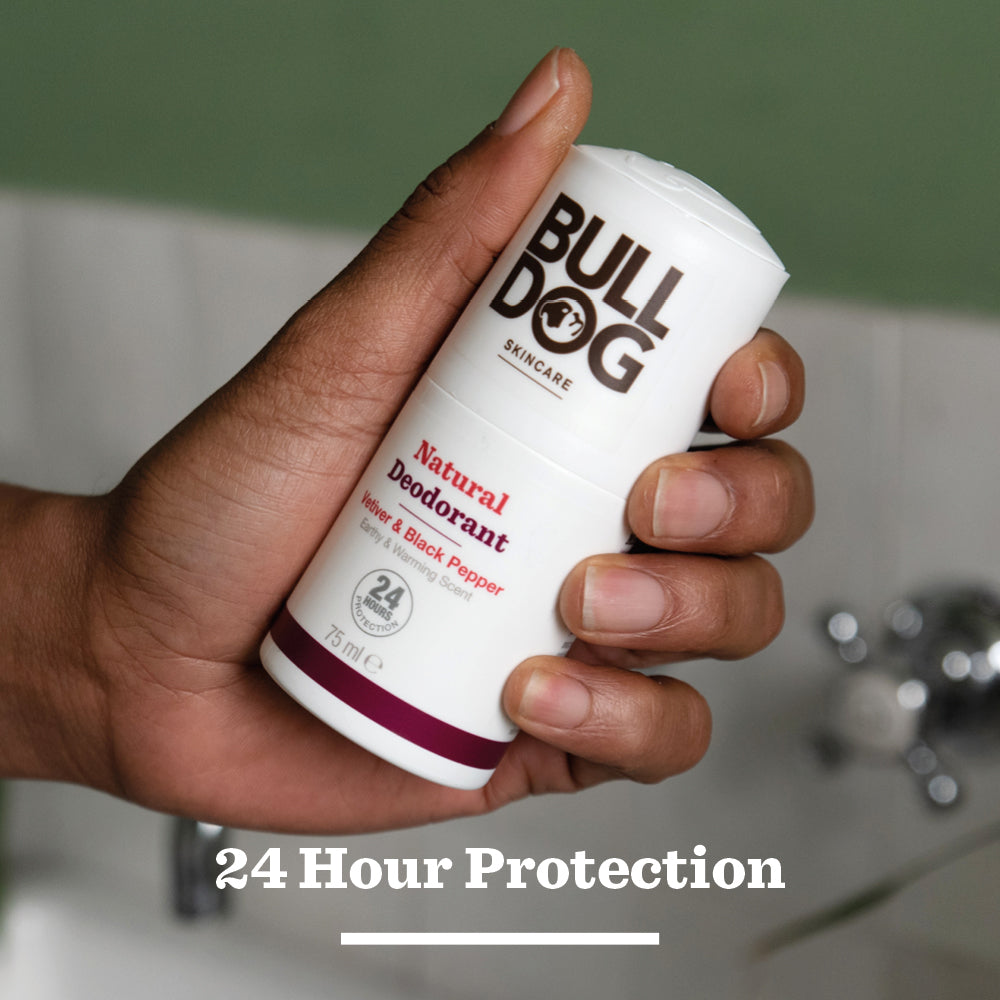 A hand holds a stick of Vetiver & Black Pepper Natural Deodorant; text below reads 24 hour odour protection.