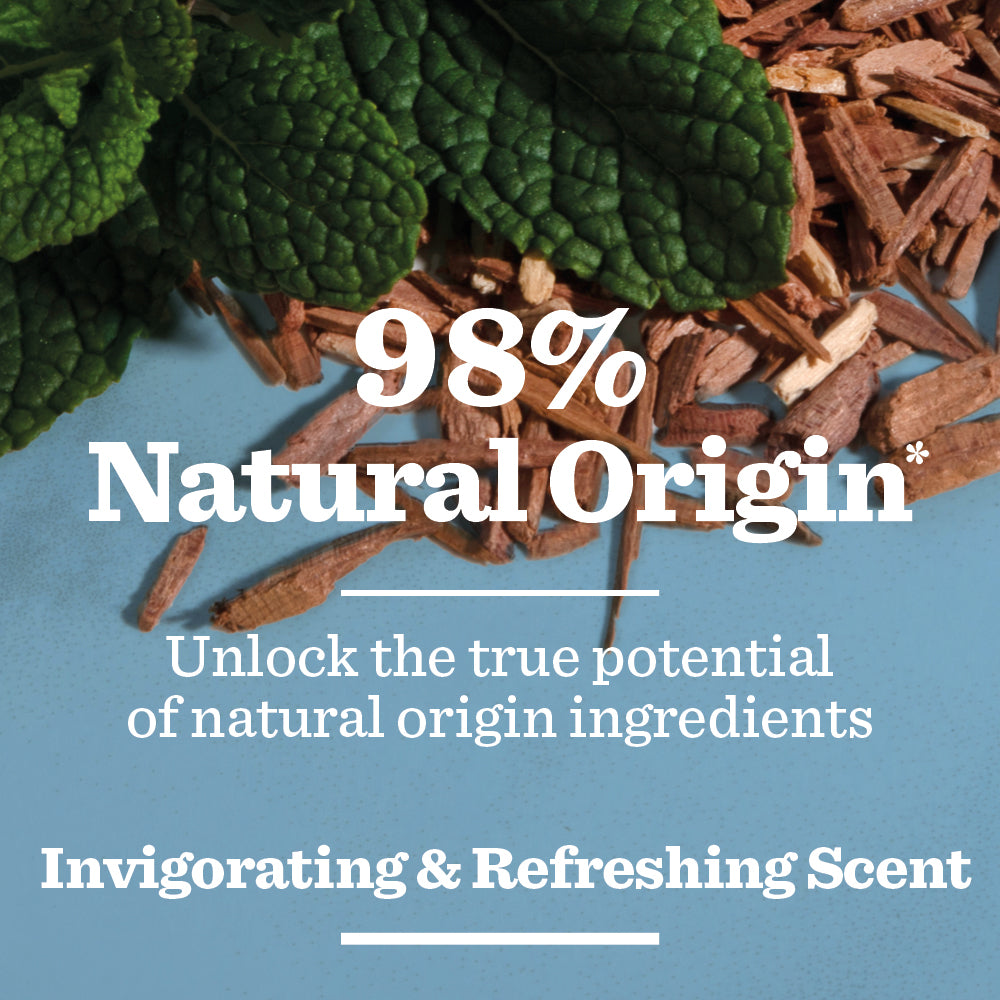 Close-up of green mint leaves and brown wood chips on blue with text: 98% Natural Origin*. Fresh Mint & Cedarwood Spray Deodorant—vegan formula with invigorating, refreshing scent. Unlock nature’s true potential.