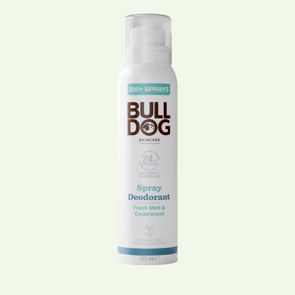 A white can of Fresh Mint & Cedarwood Spray Deodorant features teal and brown text, a clear cap, and contains 125 ml. Made with natural origin ingredients, this Bulldog Skincare vegan deodorant offers a refreshing scent.