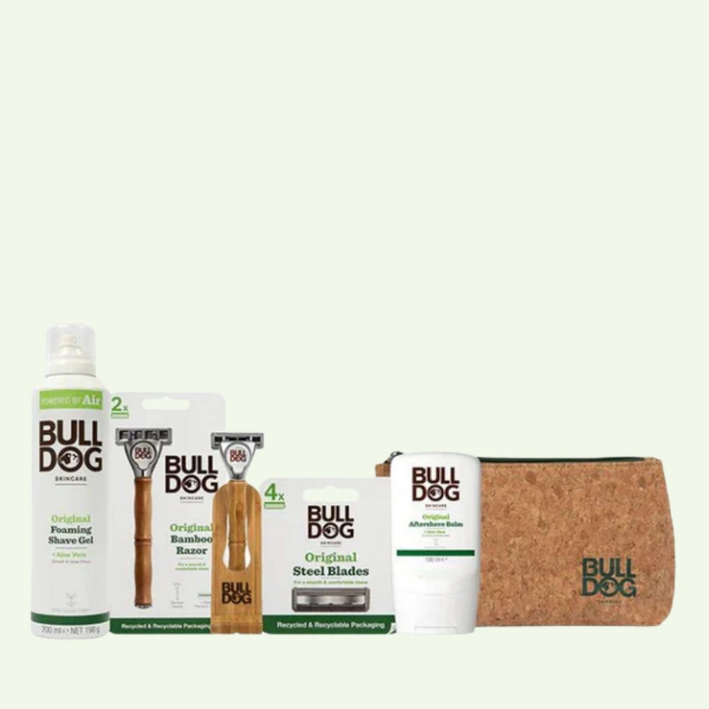Explore the Original Shaving Essentials, featuring a bamboo razor, steel blades, shave gel, aftershave balm, and a cork toiletry bag—all presented on a light background.